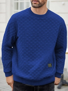 Detailed view of men's blue long-sleeve knit sweater with checkerboard texture