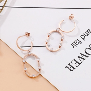 Vue détaillée des boucles d'oreilles géométriques en or rose avec zircons blancs brillants