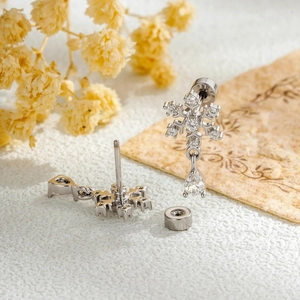 Silver snowflake earrings with zircon stones and water drop pendants on vintage background