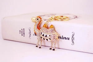 Detail of a golden camel keychain with sparkling rhinestones and lobster clasp on books