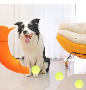 Orange automatic pet ball launcher with three tennis balls for indoor dog exercise