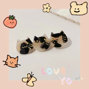 Close-up of cute black and white acetate cat hair clips with shiny finish and art details