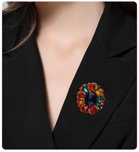 Macro detail of a vintage floral brooch with colorful crystals on a black suit jacket