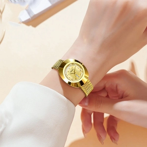 Close-up of gold tonneau women's watch with rhinestone bracelet and date display window