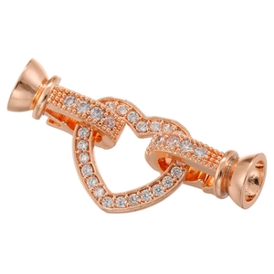 Macro detail of rose gold heart interlocking clasp with cubic zirconia pave setting