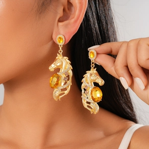 Vintage gold horse head earrings with yellow crystal and rhinestone detailing on model