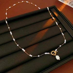 Détail d'un collier de perles vintage avec fermoir à bascule et perle baroque