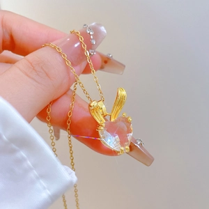 Detail of heart-shaped crystal pendant with rabbit ears on a gold titanium chain