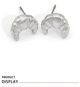 Macro shot of silver croissant stud earrings showing polished metallic texture and details