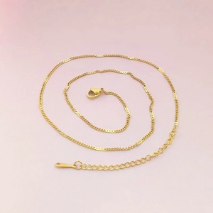 Close-up of gold stainless steel curb chain with lobster clasp and adjustable link extender