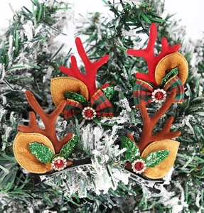 Detailed view of Christmas reindeer antler hair clips with plush textures and bells