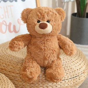 Gros plan d'un ours en peluche marron assis sur un pouf tressé dans un décor doux