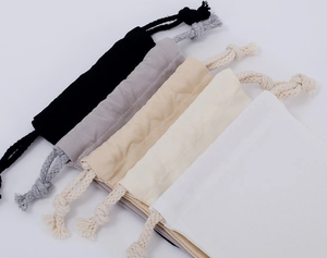 Detail of five multi-colored cotton drawstring pouches in black grey beige cream and white