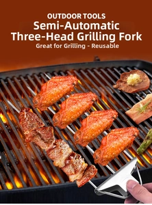 Action shot of three-prong stainless steel BBQ fork with slider grilling meat over charcoal