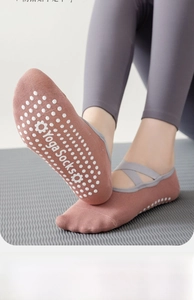Detail von rosa Yoga-Socken mit Anti-Rutsch-Silikonpunkten und grauen Kreuzgurten