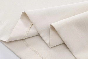 Macro view of cream-colored twill fabric showing soft texture and premium weave detail