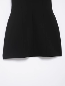 Detailed view of the pleated black dress hem featuring clean stitching and woven fabric
