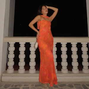 Détail de la robe longue bustier orange à fleurs avec rubans dans un cadre extérieur
