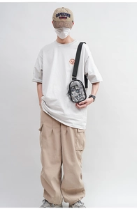 Close-up of a clear PVC crossbody bag worn by a model to show texture and size details