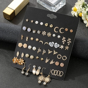 Detailed assortment of golden and silver earrings with rhinestones on black display card