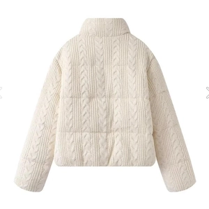 Detail view of the back of a beige knit puffer jacket with cable pattern texture