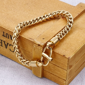 Close-up of a gold vintage keel chain bracelet displayed on a rustic wooden gift box