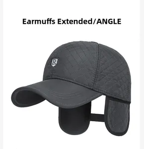 Detail of dark grey quilted winter cap showing unfolded ear flaps and metal letter logo