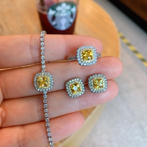 Detail of square yellow gemstone jewelry set including ring, bracelet and stud earrings