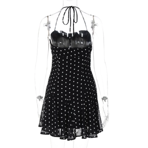 Detail view of the back of a black polka dot halter dress with a neck tie fastening
