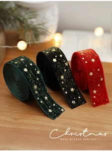 Close-up of velvet Christmas ribbons with gold star patterns in red, green, and black