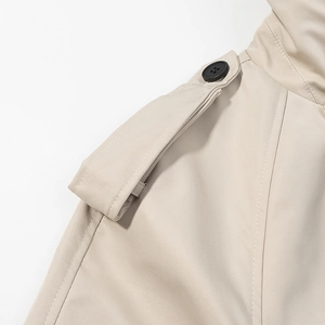 Trench-coat beige avec épaulettes détaillées et design classique à boutons noirs