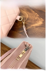 Detail of pink quilted bucket bag with gold-tone hardware and detachable strap clasp