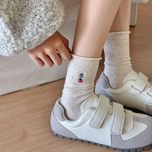 Chaussettes en coton crème avec broderie chien et pois portées avec baskets blanches