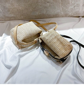 Detail of woven straw shoulder bags with herringbone texture and gold metal buckles