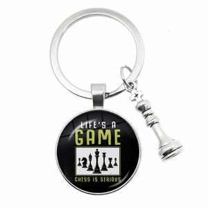 Silver chess queen keychain with glass pendant featuring Life's a Game text print