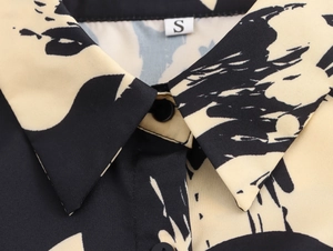 Close-up of shirt collar with black and yellow abstract print and size S woven label