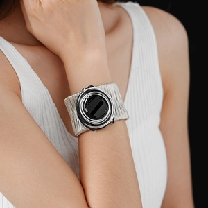 Close-up of multi-layer silver wired bracelet with round black gemstone embellishment
