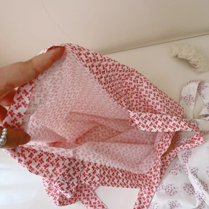 Gros plan d'un sac cabas en coton blanc avec motif de nœuds rouges imprimé partout