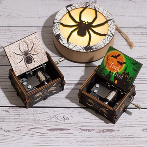 Halloween wooden hand-crank music boxes with pumpkin and bat prints on white wood