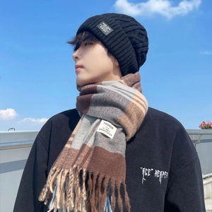 Winter set with black knit beanie and brown plaid scarf featuring fringe details