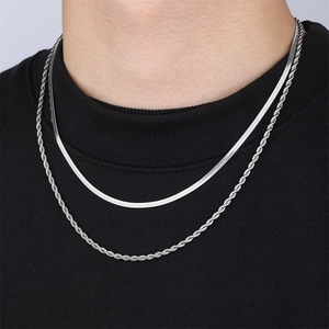 Close-up of layered silver stainless steel snake and twist rope chains on a model
