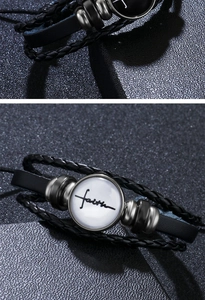 Close-up of black braided leather bracelet with a glass dome featuring faith lettering