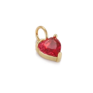 Macro shot of heart-shaped red zircon pendant with gold-plated claw setting and bail