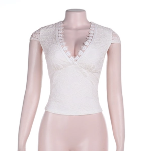 Dettaglio del top bianco in pizzo con scollo a V e motivi floreali ricamati