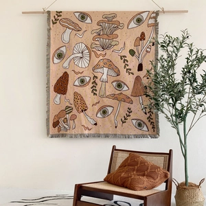 Bohemian woven tapestry with vintage mushroom and eye patterns including wooden hanging pole