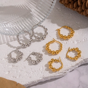 Boucles d'oreilles boules en acier inoxydable doré et argenté sur pierre blanche