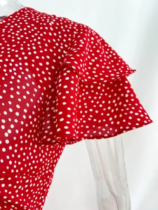 Detail of red polka dot dress featuring double-layered ruffle sleeves and chiffon fabric