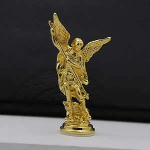 Vintage golden angel statue with wings and spear on a round metal pedestal base