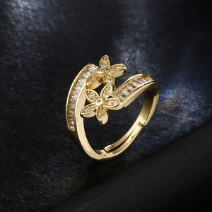 Elegant gold flower open ring with sparkling cubic zirconia on a black textured background