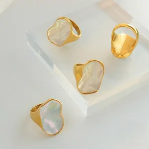 Anelli in acciaio al titanio dorato con intarsio in madreperla e design fluido organico